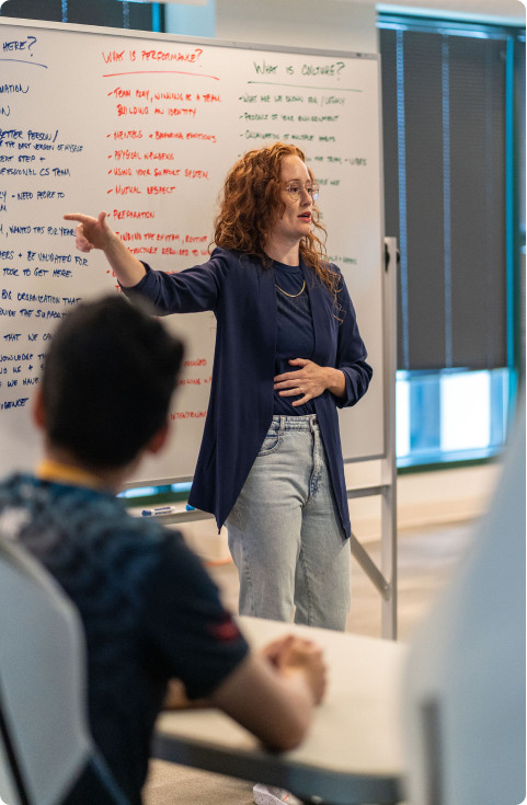 A woman on Secretlab's Ergonomics Advisory Board in a meeting room explaining the science behind ergonomic comfort and performance.